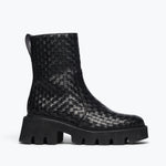 Black woven Chelsea boot by Freda Salvador featuring a sleek silhouette and elastic side panels, front view.