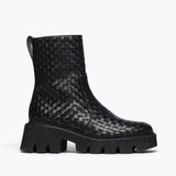 Black woven Chelsea boot by Freda Salvador featuring a sleek silhouette and elastic side panels, front view.