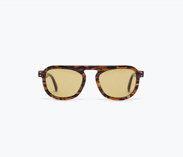 Sunglasses with tortoiseshell frame and gold lenses on a white background