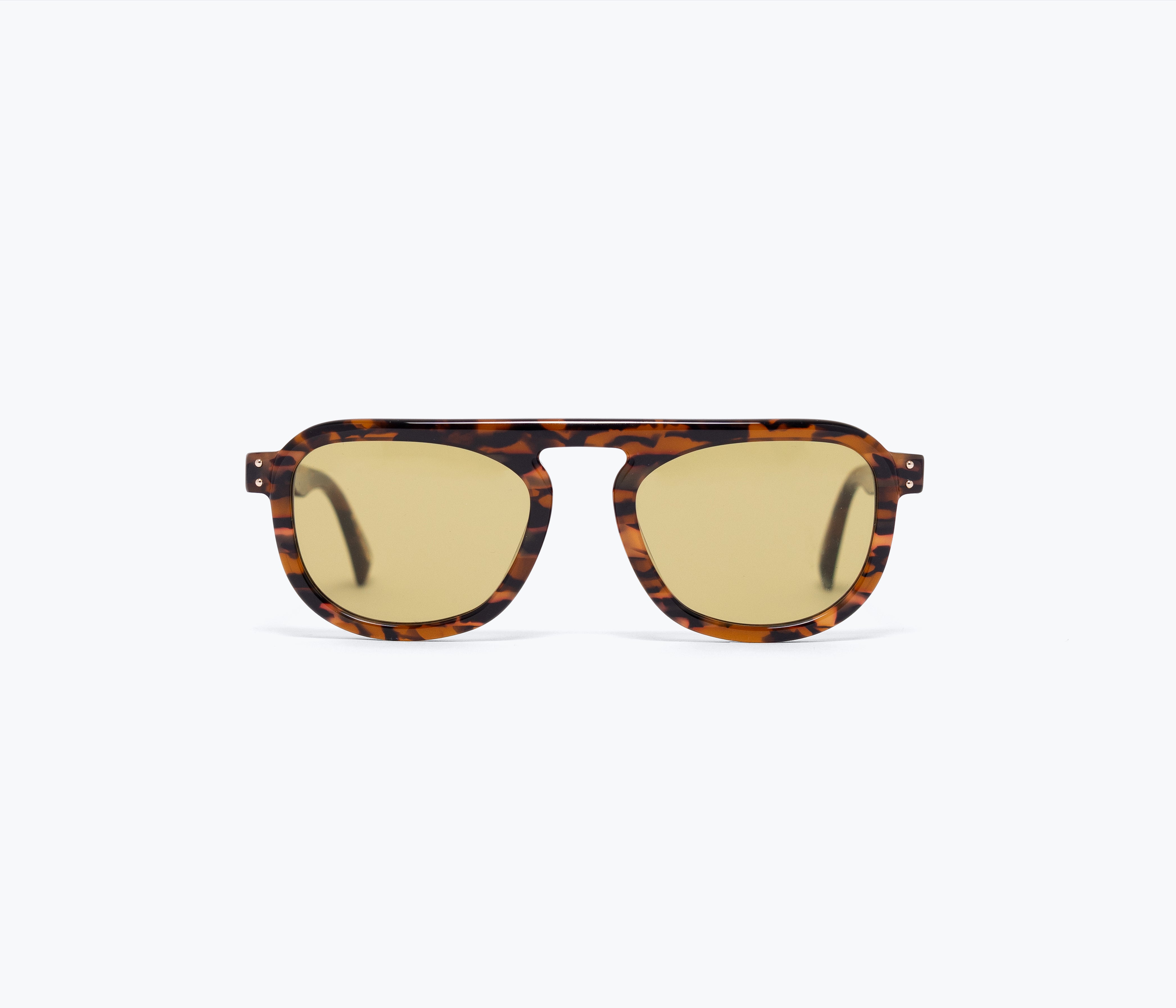 Sunglasses with tortoiseshell frame and gold lenses on a white background