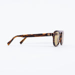 Sunglasses with tortoiseshell frame and gold lenses on a white background