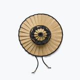 Woven straw bag with black trim on a white background