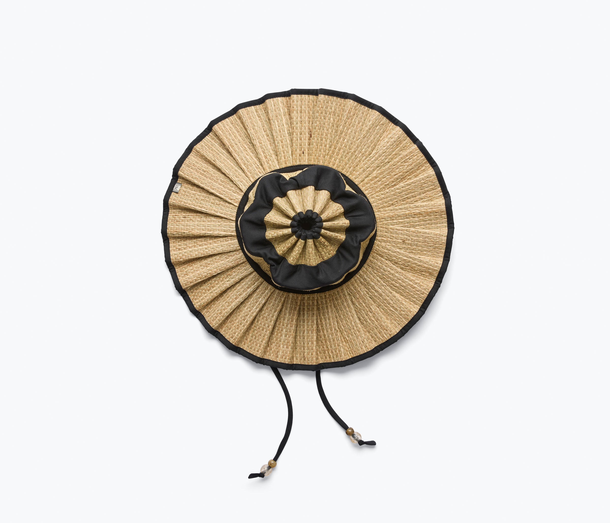 Woven straw bag with black trim on a white background