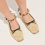 Beige lace-up shoes worn with decorative anklets on a light background