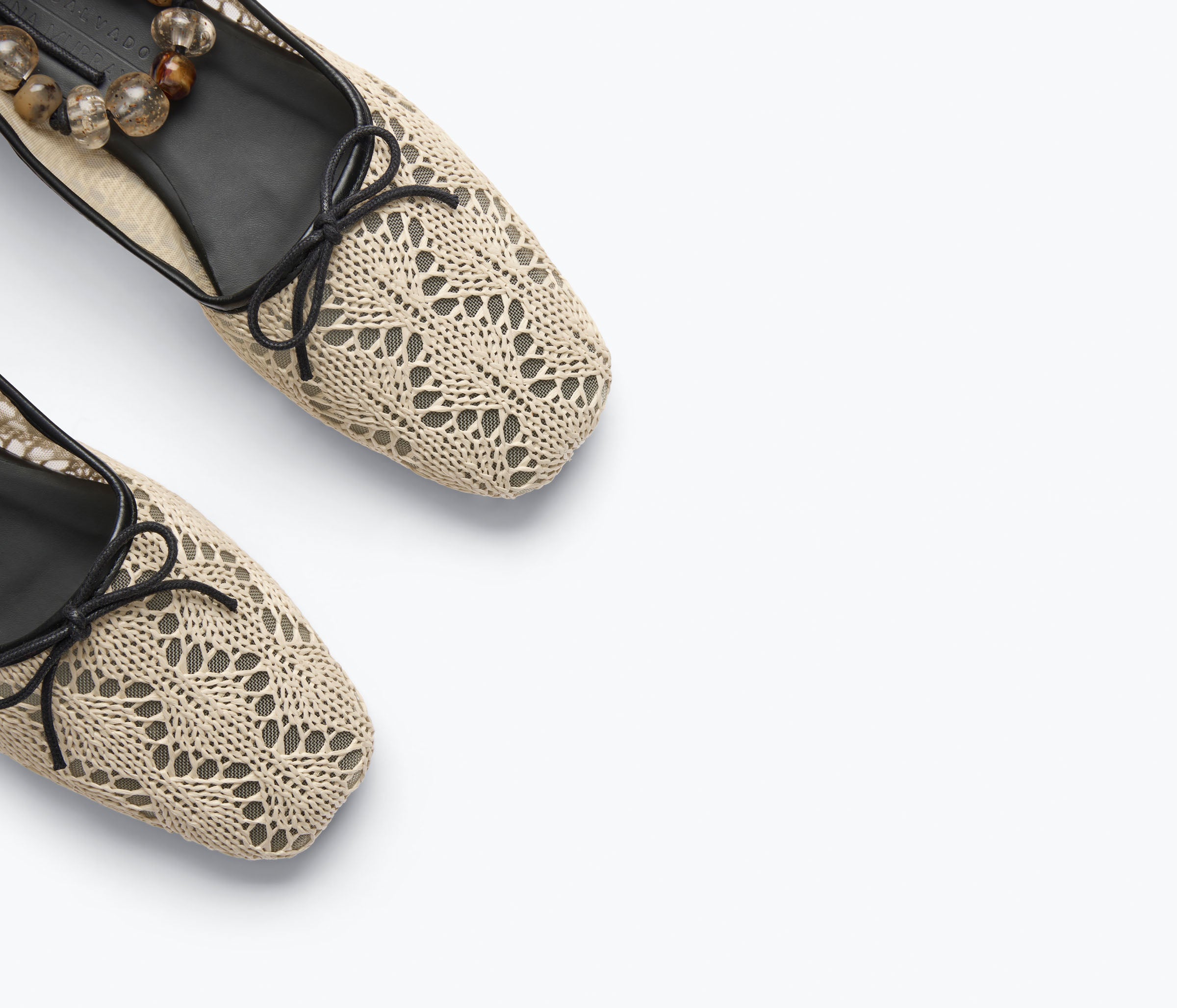 Pair of beige lace-up flats on a light gray background