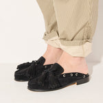 Black suede Leon tassel penny loafer mule by Freda Salvador, showcasing its sleek design and tassel details.