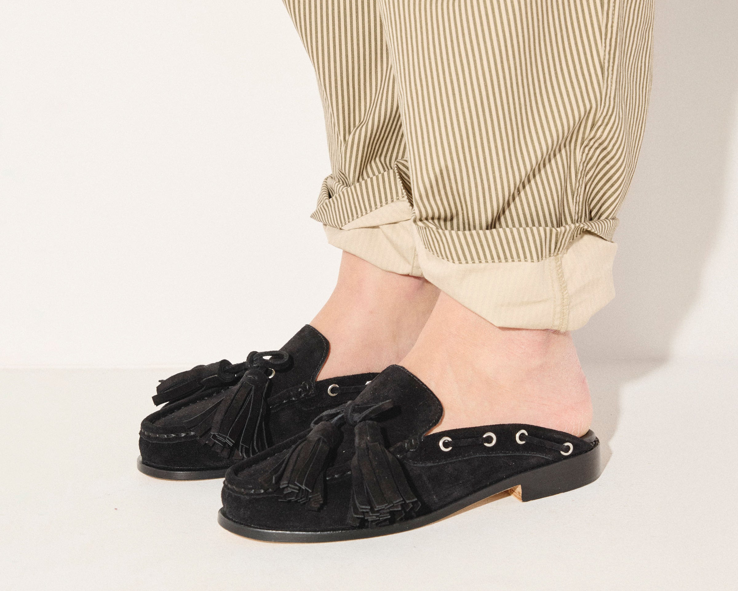 Black suede Leon tassel penny loafer mule by Freda Salvador, showcasing its sleek design and tassel details.