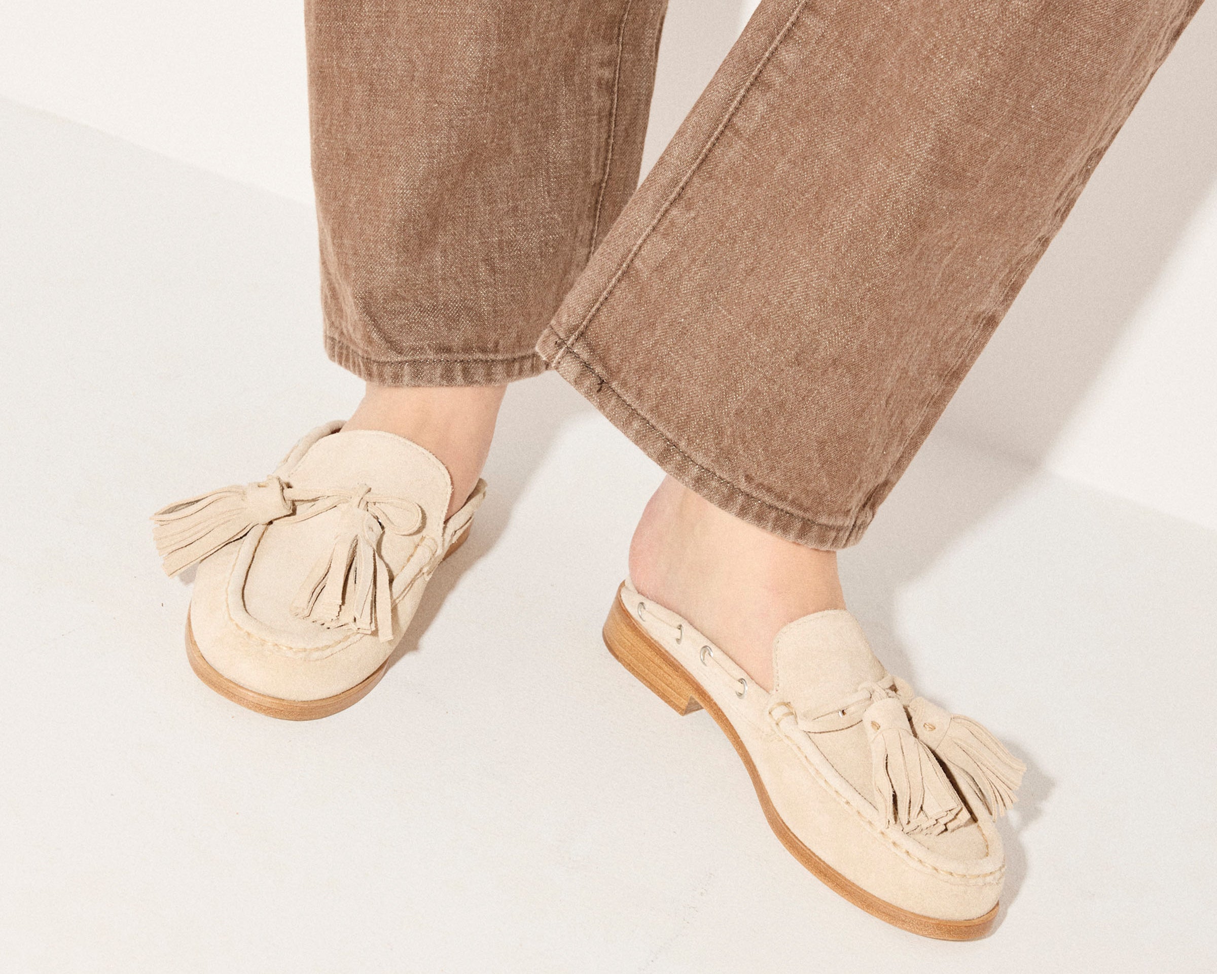 Freda Salvador Leon Tassel Penny Loafer Mule in Sahara suede featuring tassel detail and slip-on mule design.