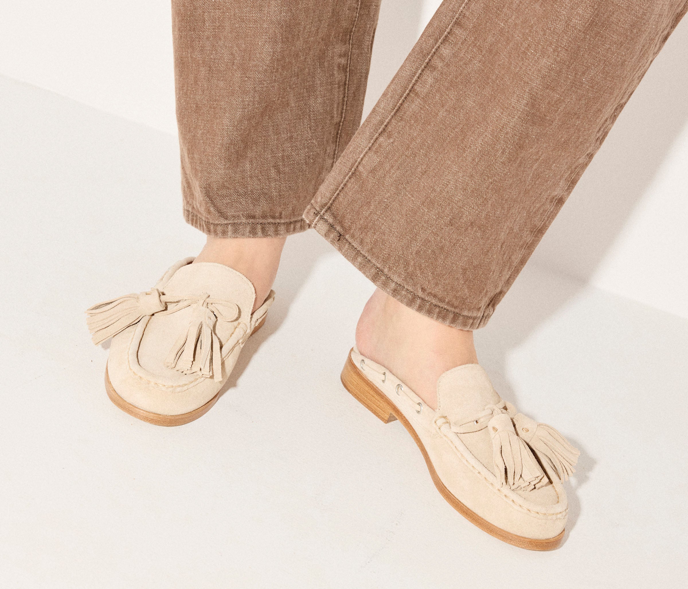 Freda Salvador Leon Tassel Penny Loafer Mule in Sahara suede featuring tassel detail and slip-on mule design.