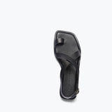 Black PAXTON sandal by FREDA SALVADOR featuring a sleek strap design and open toe style.