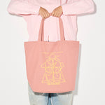 Limited edition illustrated tote bag by Freda Salvador in dusty rose with artistic design, perfect for carrying marketing materials.