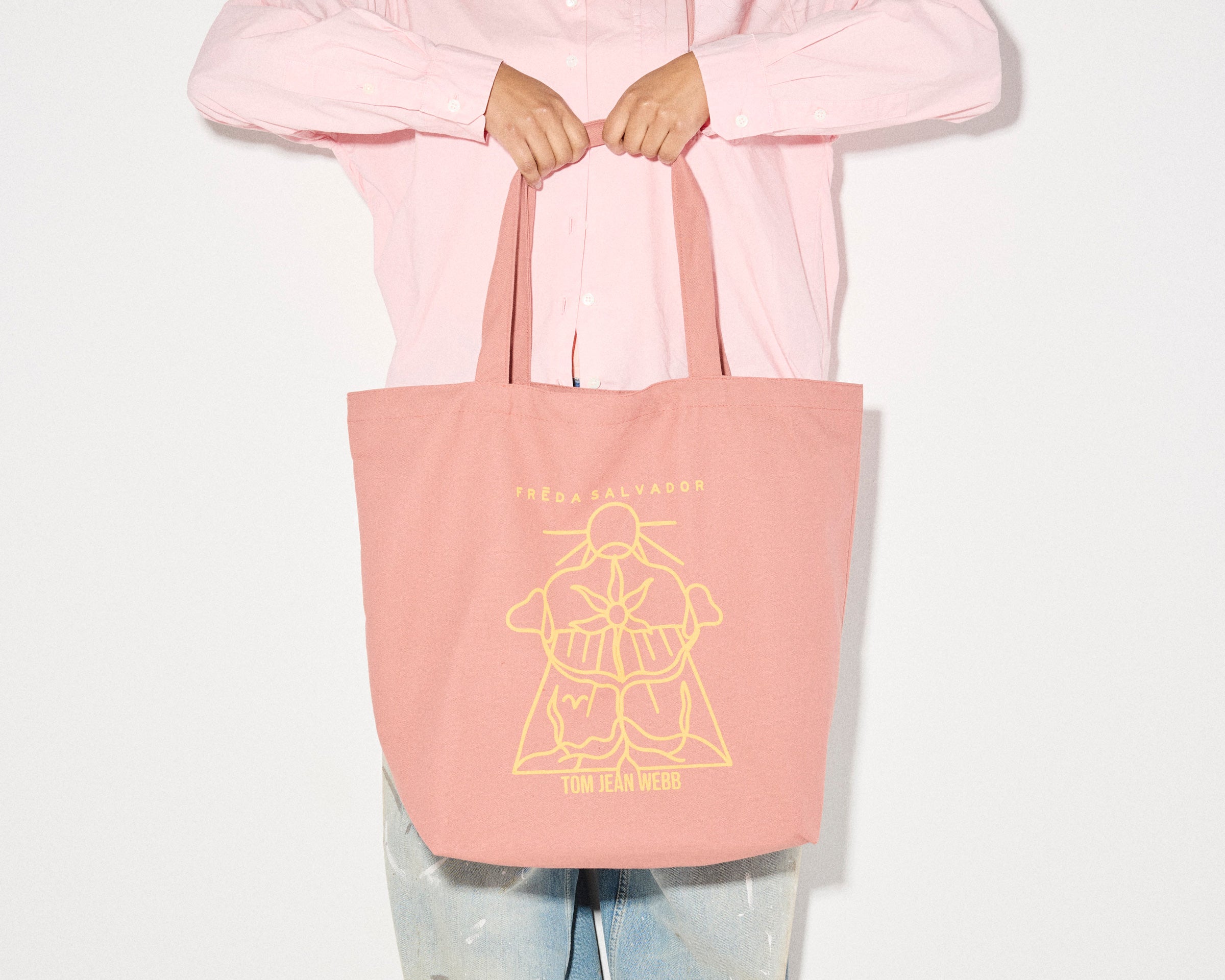 Limited edition illustrated tote bag by Freda Salvador in dusty rose with artistic design, perfect for carrying marketing materials.